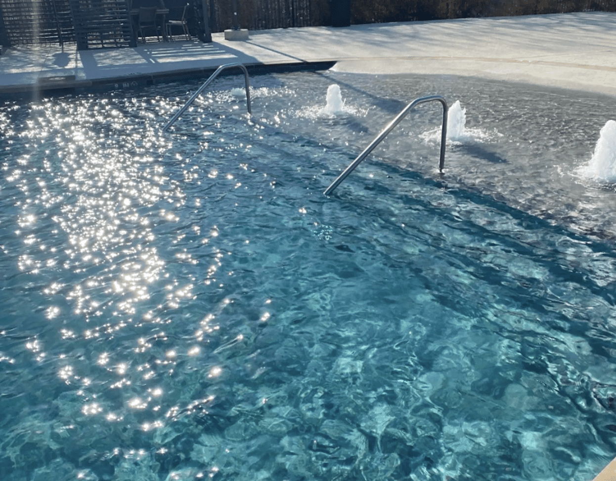 Sunlit pool with sparkling water surface.