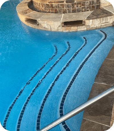 Swimming pool steps with tile accents.